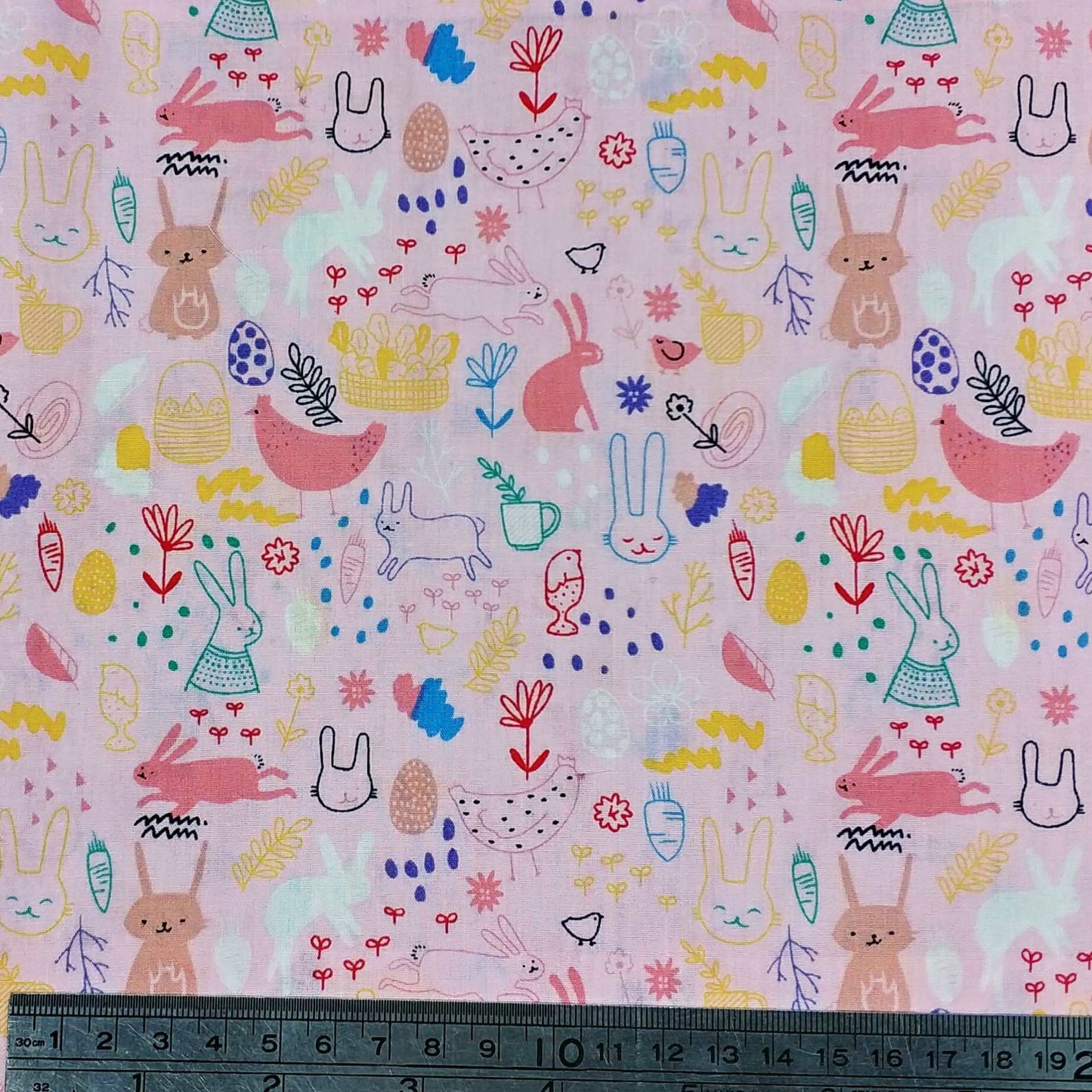 Fabric with colorful bunny and chick pattern on a pink background