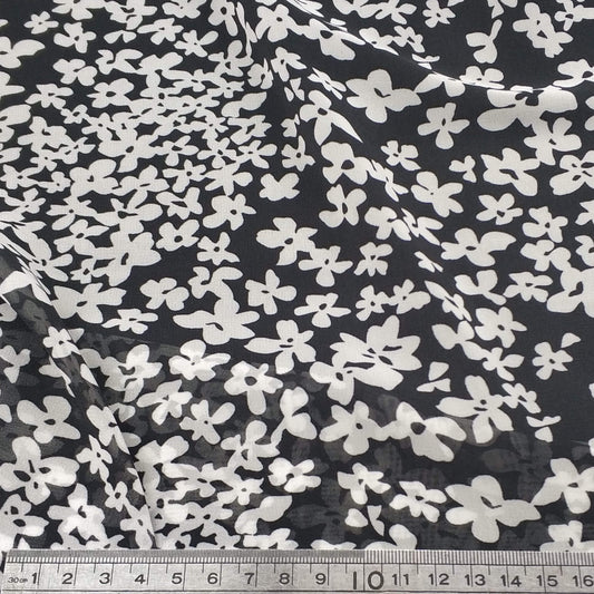 Floral patterned chiffon fabric with white flowers on a black background