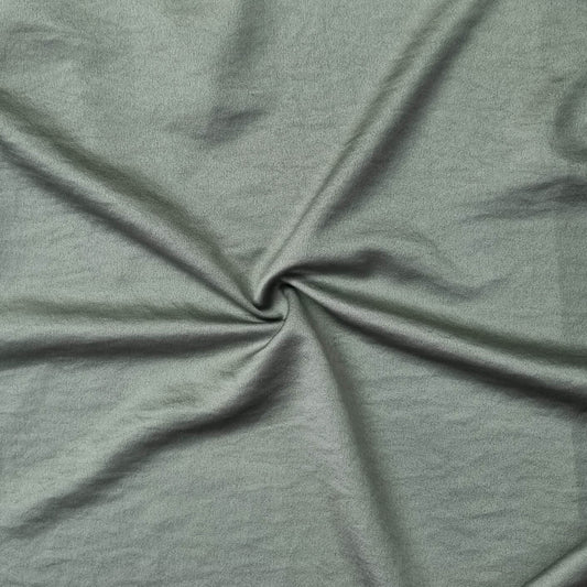 Woven fabric with a slightly crinkled and sand‑washed texture in green