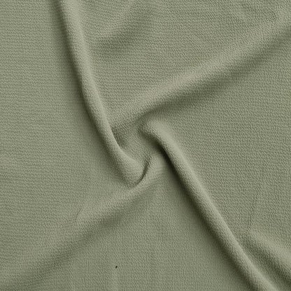 green fabric with a textured pattern