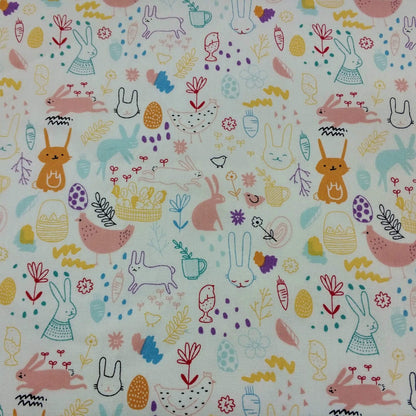 Patterned fabric with colorful rabbits, flowers, and other elements on a light background