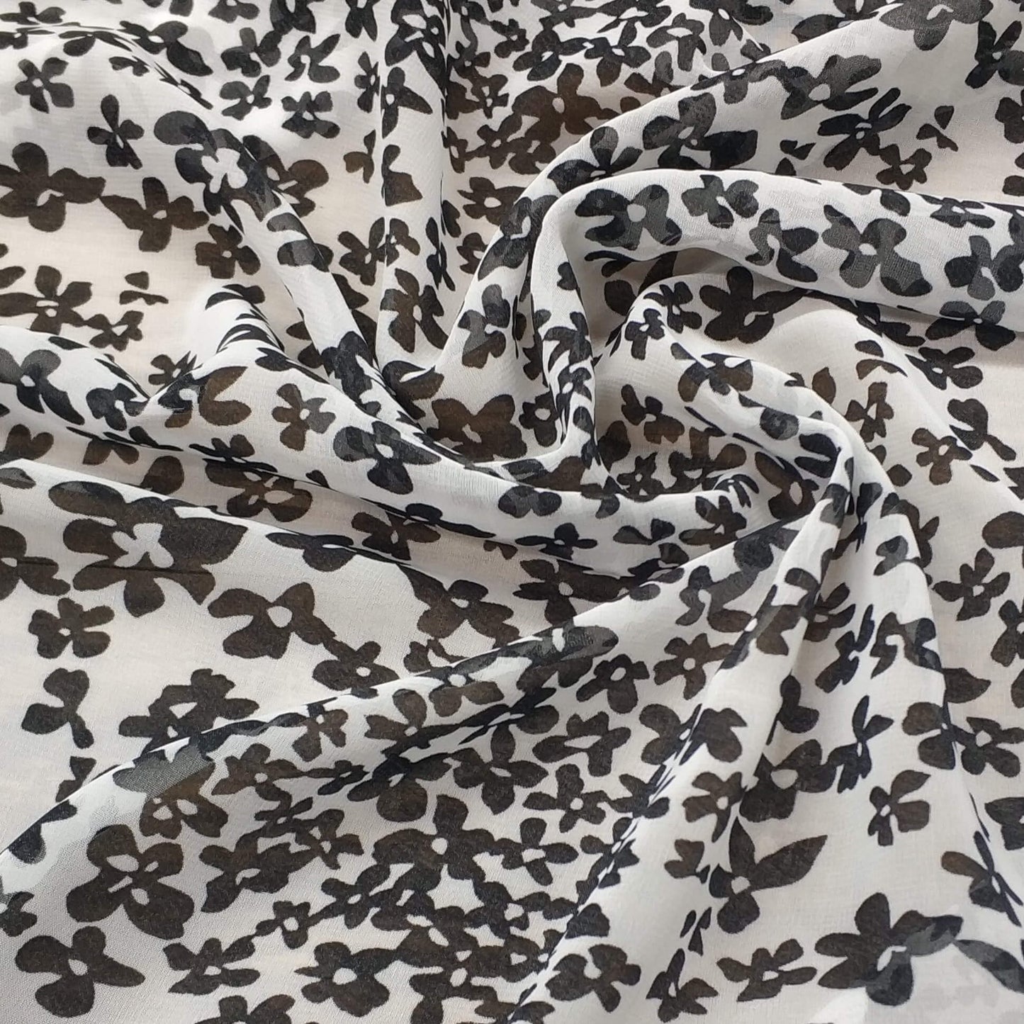 Floral patterned chiffon fabric with black flowers on a white background