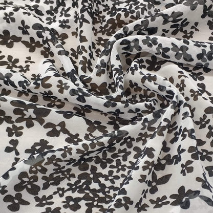 Floral patterned chiffon fabric with black flowers on a white background