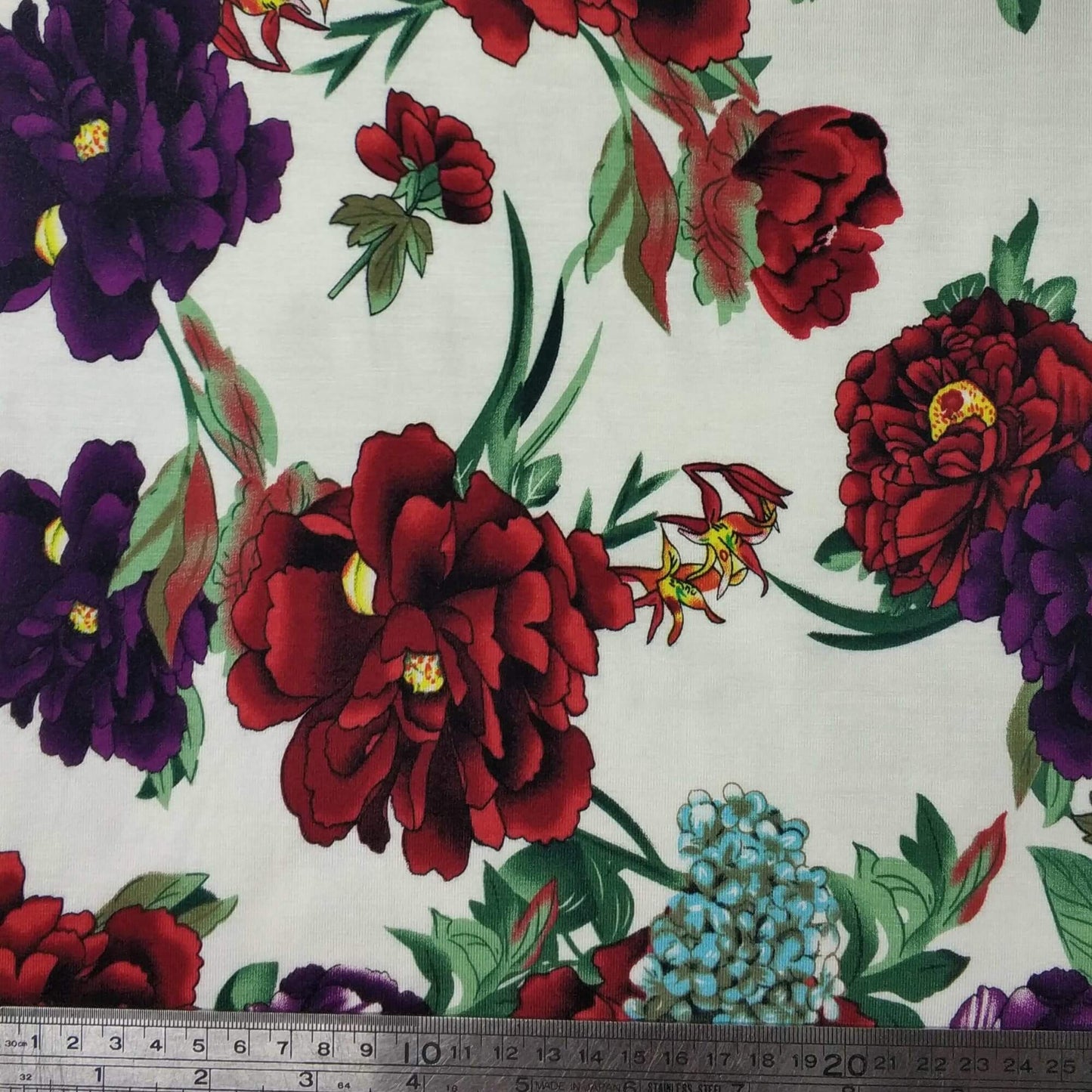 Floral Printed Viscose Jersey fabric pattern with red and purple flowers on a white background