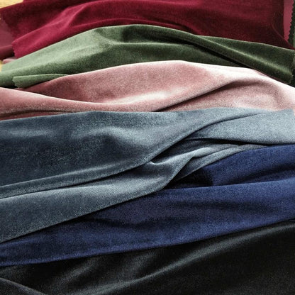 Stack Of Multicolored Velvet Fabric Swatches Including Burgundy, Green, Pink, Blue, And Black.