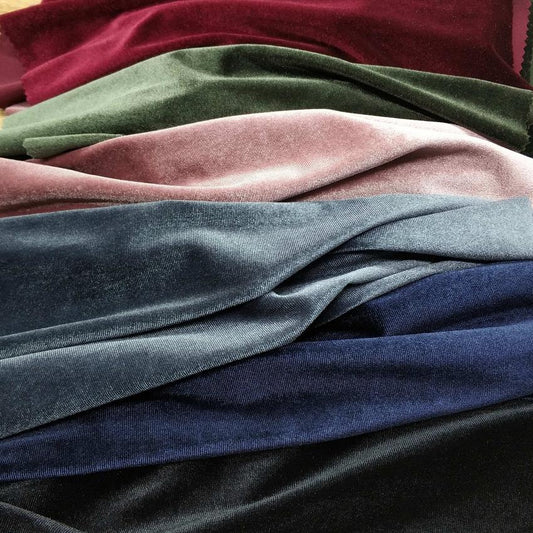 Stack Of Multicolored Velvet Fabric Swatches Including Burgundy, Green, Pink, Blue, And Black.
