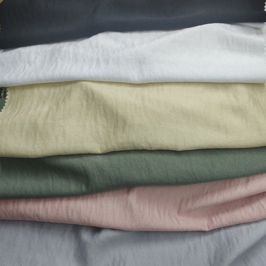 Woven fabric with a slightly crinkled and sand‑washed texture