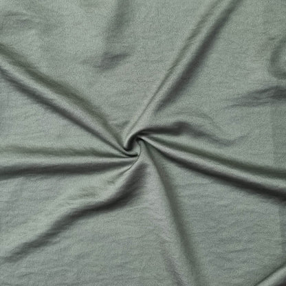 Woven fabric with a slightly crinkled and sand‑washed texture in green