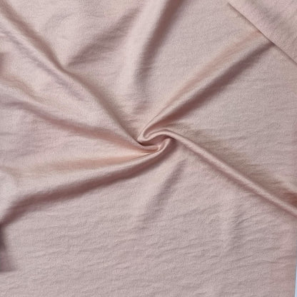 Woven fabric with a slightly crinkled and sand‑washed texture in pink